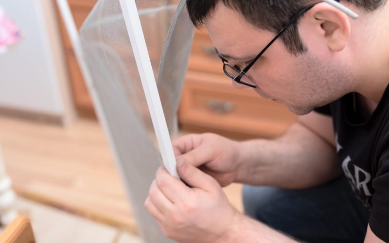 man-repairing-mosquito-net-at-home-home-improvement-concept-.jpg